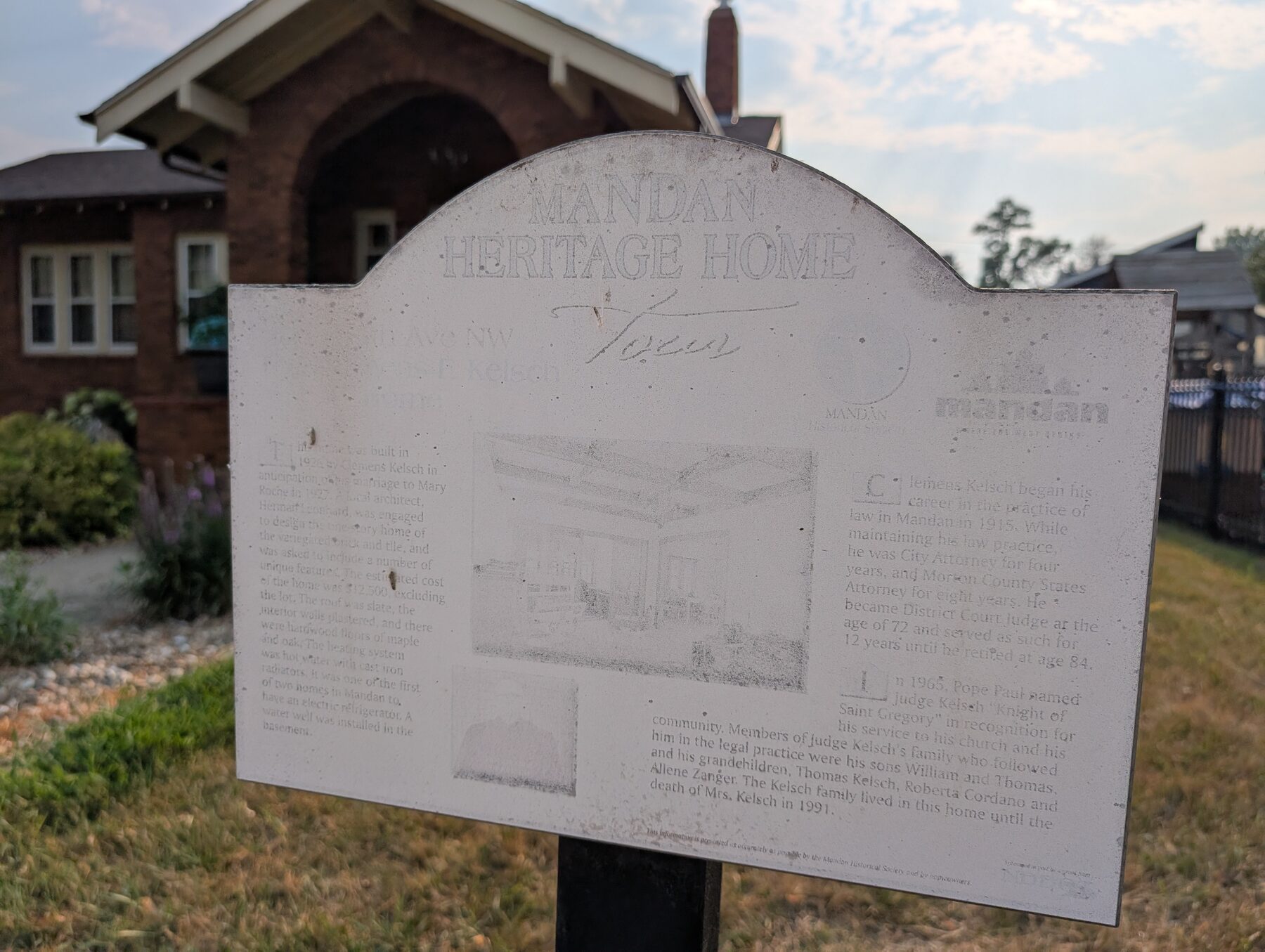 The weathered Kelsh Home heritage sign in front of the house